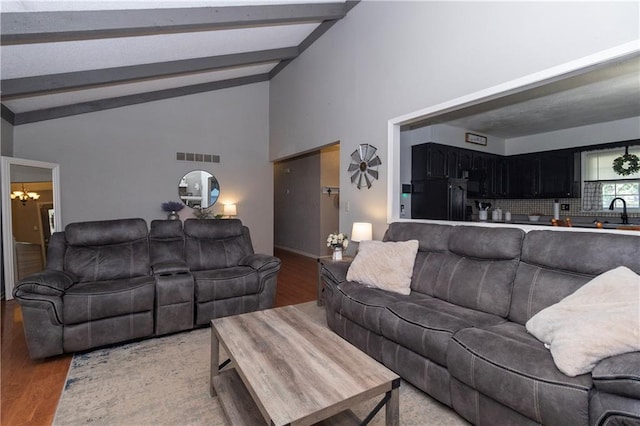 1005 SE Alice St, Blue Springs, MO 64014 - living area featuring light wood-type flooring, beamed ceiling, a chandelier, and high vaulted ceiling
