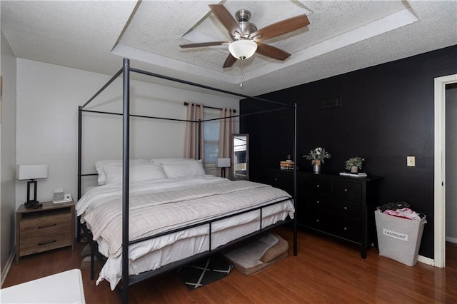 1005 SE Alice St, Blue Springs, MO 64014 - bedroom with wood finished floors, a tray ceiling, a textured ceiling, and ceiling fan