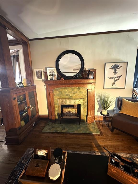 4020 Campbell St, Kansas City, MO 64110 - living area with wood finished floors, a brick fireplace, and crown molding