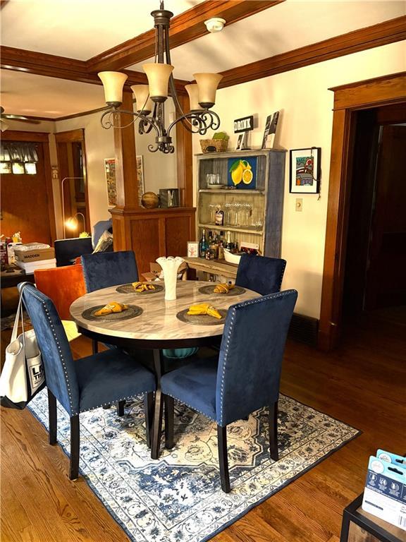 4020 Campbell St, Kansas City, MO 64110 - dining area featuring crown molding, wood finished floors, a chandelier, and ceiling fan