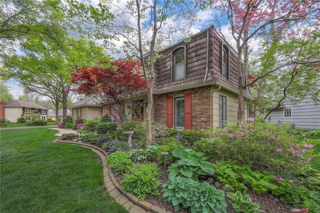 9015 Outlook Dr, Overland Park, KS 66207 - view of home's exterior with mansard roof, brick siding, and a yard