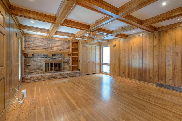9015 Outlook Dr, Overland Park, KS 66207 - unfurnished living room with a ceiling fan, beam ceiling, wood finished floors, wooden walls, and a fireplace