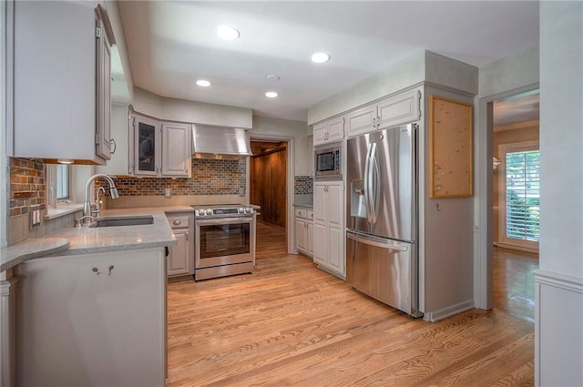 9015 Outlook Dr, Overland Park, KS 66207 - kitchen with appliances with stainless steel finishes, wall chimney exhaust hood, light wood-style flooring, backsplash, and recessed lighting
