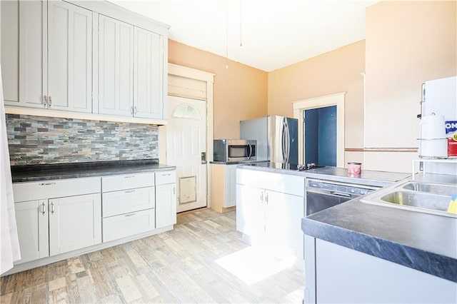 2627 Renick St, Saint Joseph, MO 64507 - kitchen with stainless steel appliances, backsplash, light wood-type flooring, dark countertops, and white cabinets