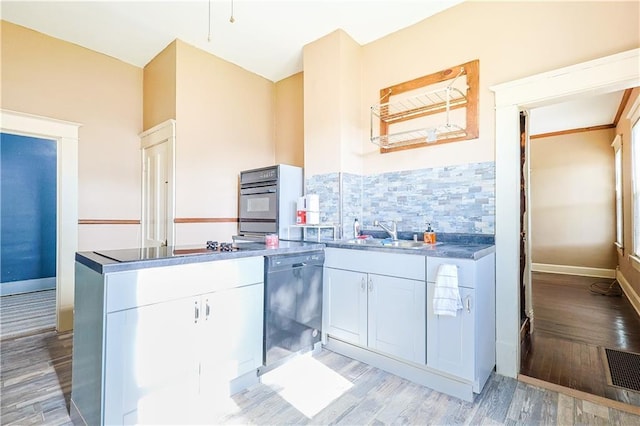 2627 Renick St, Saint Joseph, MO 64507 - kitchen featuring black appliances, backsplash, light wood-style flooring, and white cabinetry