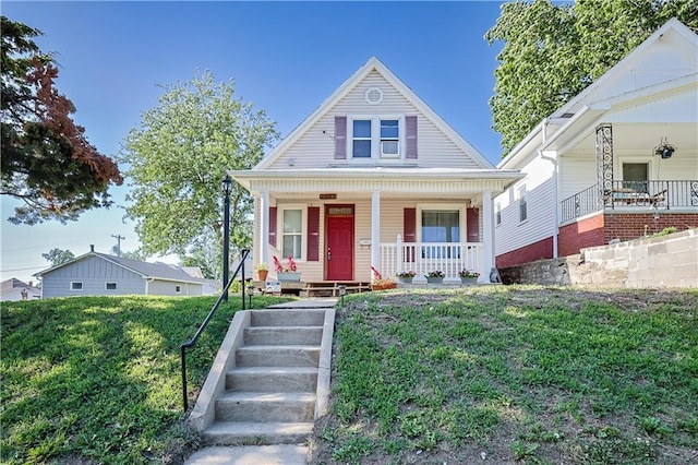 2627 Renick St, Saint Joseph, MO 64507 - bungalow with covered porch, a front yard, and stairs