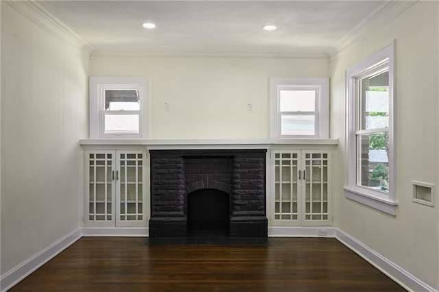 5236 Woodland Ave, Kansas City, MO 64110 - unfurnished living room featuring crown molding, a brick fireplace, wood finished floors, and recessed lighting