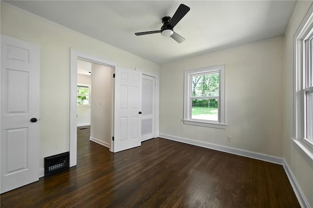 5236 Woodland Ave, Kansas City, MO 64110 - unfurnished bedroom featuring dark wood-style flooring, multiple windows, and ceiling fan