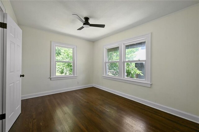 5236 Woodland Ave, Kansas City, MO 64110 - unfurnished bedroom with dark wood-style floors and a ceiling fan