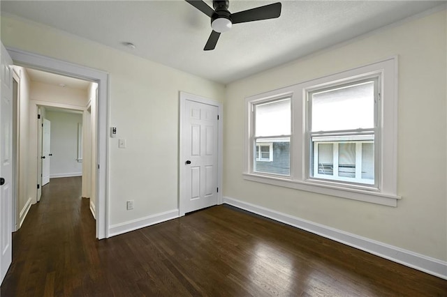 5236 Woodland Ave, Kansas City, MO 64110 - unfurnished bedroom with dark wood-style floors, a ceiling fan, and a closet
