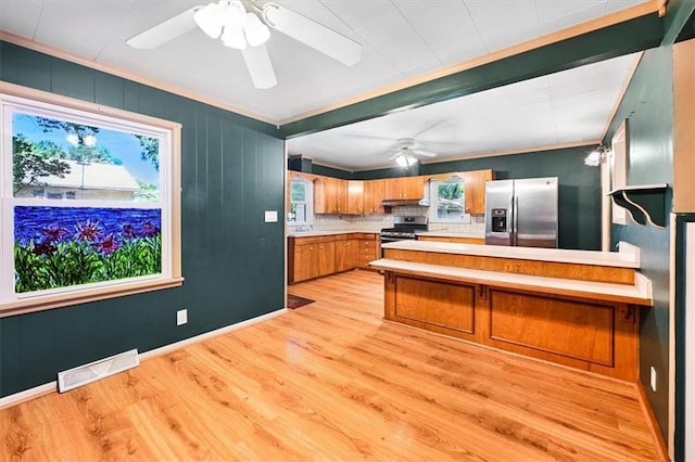 2704 Garland St, Leavenworth, KS 66048 - kitchen with appliances with stainless steel finishes, a ceiling fan, brown cabinets, light countertops, and a peninsula