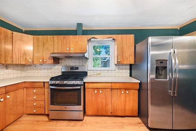2704 Garland St, Leavenworth, KS 66048 - kitchen with stainless steel appliances, wall chimney exhaust hood, light countertops, and light wood-style flooring