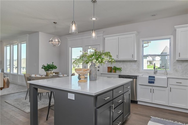 6122 Lewis Dr, Shawnee, KS 66226 - kitchen with dishwasher, white cabinetry, a kitchen island, light countertops, and a kitchen bar