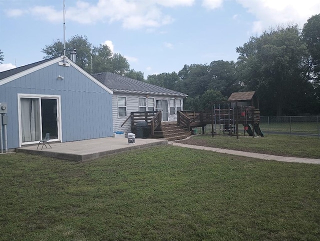 1712 S Hands St, Independence, MO 64055 - rear view of house featuring a playground, a patio, and a wooden deck