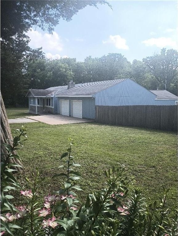 1712 S Hands St, Independence, MO 64055 - back of house featuring an attached garage and driveway