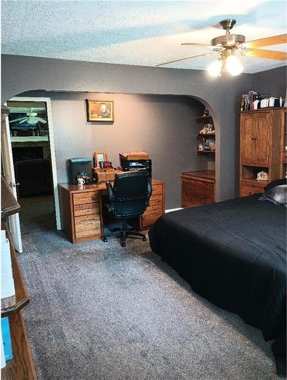 1712 S Hands St, Independence, MO 64055 - carpeted bedroom with arched walkways, a ceiling fan, and a desk