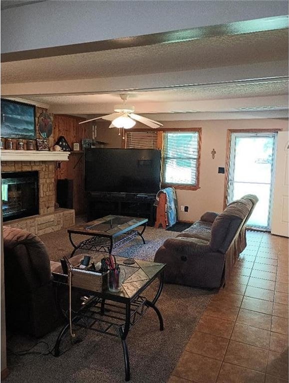 1712 S Hands St, Independence, MO 64055 - living area with a ceiling fan, a fireplace, tile patterned flooring, and a textured ceiling