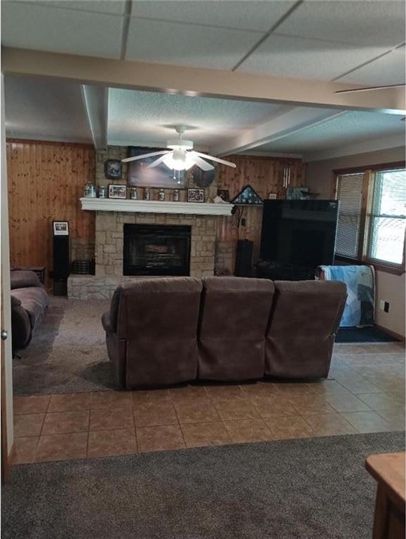 1712 S Hands St, Independence, MO 64055 - living room with a fireplace, ceiling fan, wooden walls, beam ceiling, and tile patterned floors