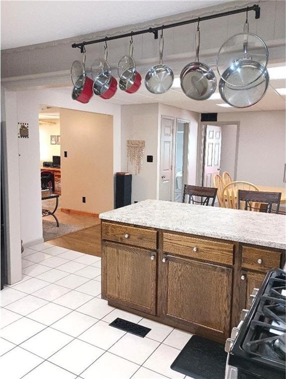 1712 S Hands St, Independence, MO 64055 - kitchen with range, light countertops, light tile patterned floors, and a center island