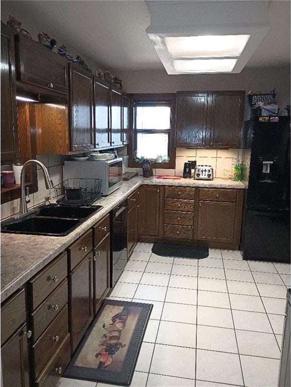 1712 S Hands St, Independence, MO 64055 - kitchen with black appliances, dark brown cabinets, light tile patterned floors, and light countertops