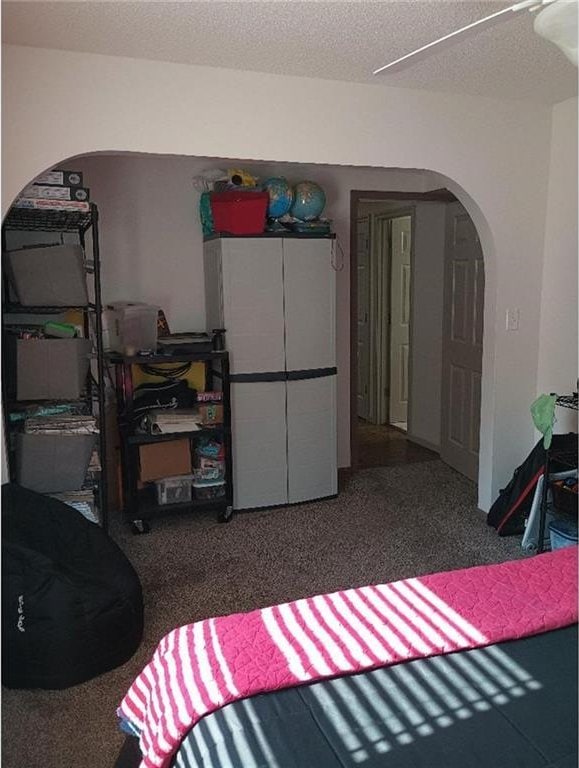 1712 S Hands St, Independence, MO 64055 - carpeted bedroom featuring arched walkways and a textured ceiling