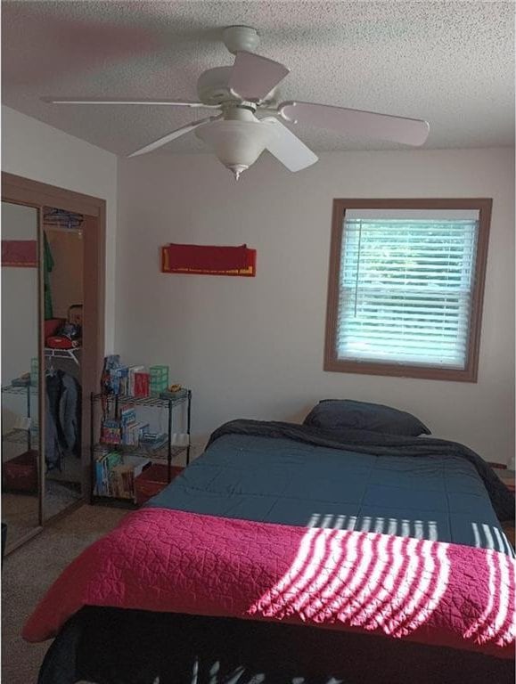1712 S Hands St, Independence, MO 64055 - bedroom with a closet, a textured ceiling, and a ceiling fan