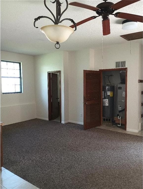 1712 S Hands St, Independence, MO 64055 - unfurnished room with electric water heater, a textured ceiling, carpet floors, and ceiling fan