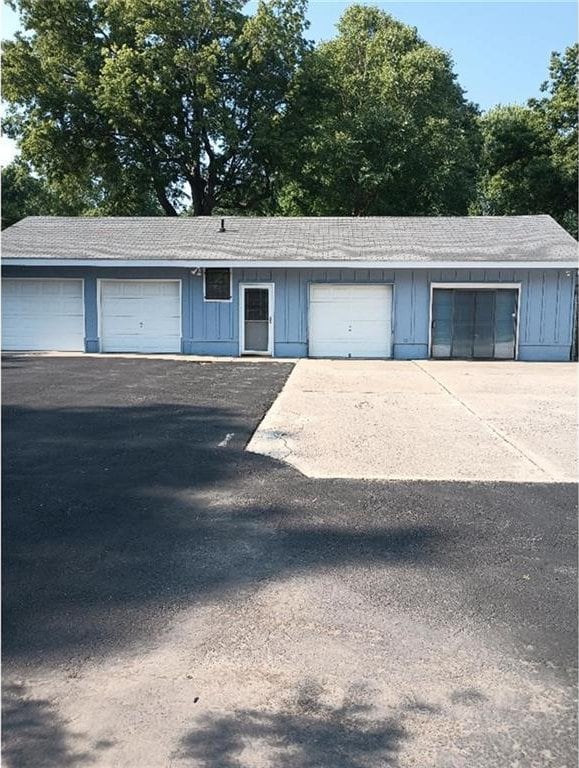 1712 S Hands St, Independence, MO 64055 - view of front of house with board and batten siding and a garage