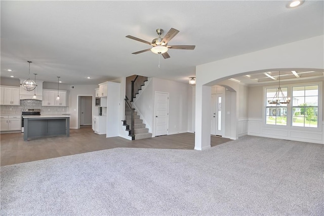 6108 Lewis Dr, Shawnee, KS 66226 - unfurnished living room with carpet, a chandelier, recessed lighting, a ceiling fan, and arched walkways