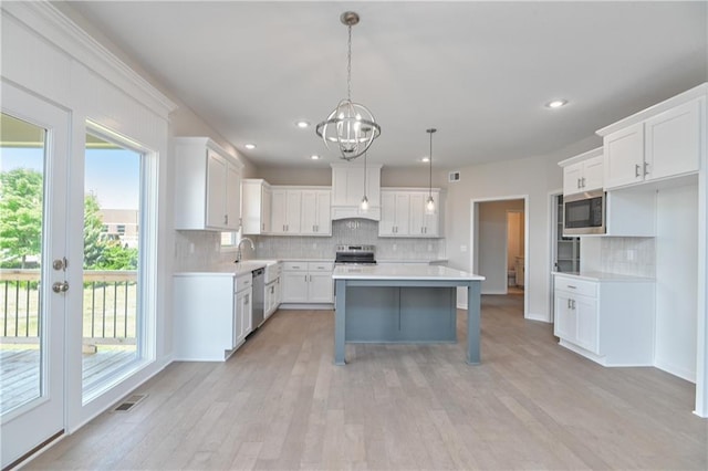 6108 Lewis Dr, Shawnee, KS 66226 - kitchen featuring appliances with stainless steel finishes, healthy amount of natural light, decorative backsplash, light wood-style floors, and recessed lighting