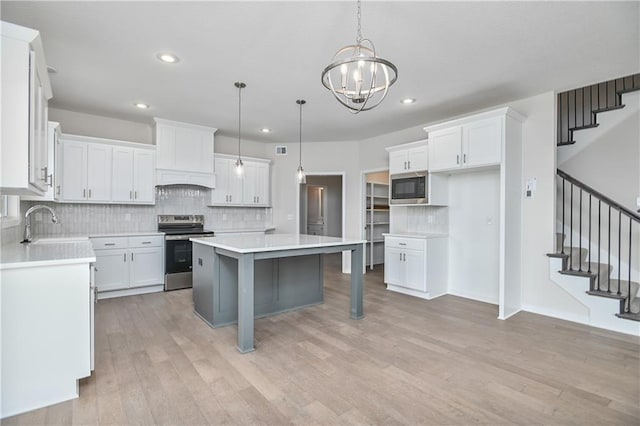 6108 Lewis Dr, Shawnee, KS 66226 - kitchen featuring stainless steel electric stove, built in microwave, tasteful backsplash, light wood-type flooring, and recessed lighting