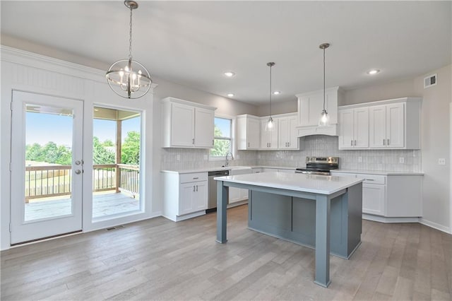 6108 Lewis Dr, Shawnee, KS 66226 - kitchen with stainless steel appliances, light countertops, white cabinetry, tasteful backsplash, and light wood finished floors