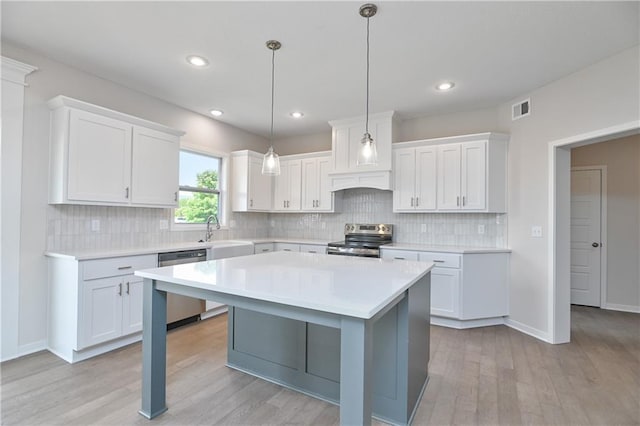 6108 Lewis Dr, Shawnee, KS 66226 - kitchen with stainless steel appliances, light countertops, light wood-style floors, white cabinetry, and backsplash
