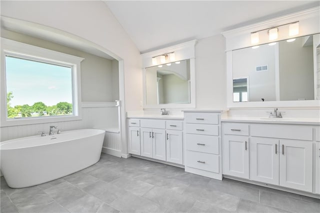 6108 Lewis Dr, Shawnee, KS 66226 - full bath featuring double vanity, a soaking tub, vaulted ceiling, and wainscoting