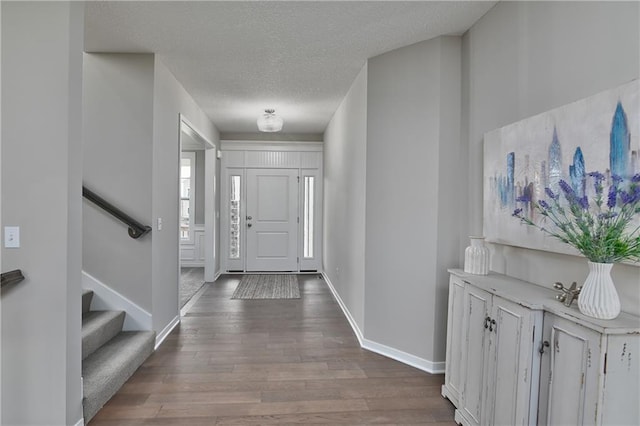 6118 Lewis Dr, Shawnee, KS 66226 - foyer entrance with wood finished floors, stairs, and a textured ceiling