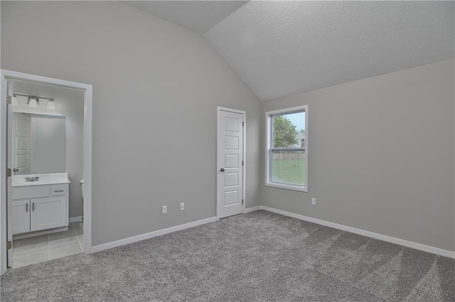 6118 Lewis Dr, Shawnee, KS 66226 - unfurnished bedroom with light colored carpet, lofted ceiling, connected bathroom, and a textured ceiling