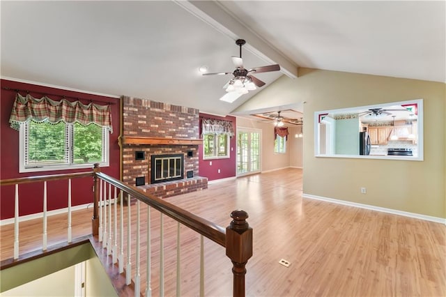 32204 Apple Hill Dr, Paola, KS 66071 - unfurnished living room featuring a ceiling fan, wood finished floors, healthy amount of natural light, and a fireplace
