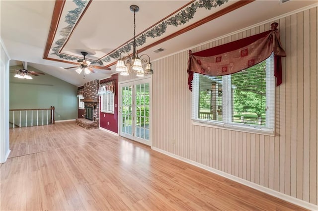 32204 Apple Hill Dr, Paola, KS 66071 - unfurnished living room featuring wood finished floors, ceiling fan, a brick fireplace, and a chandelier