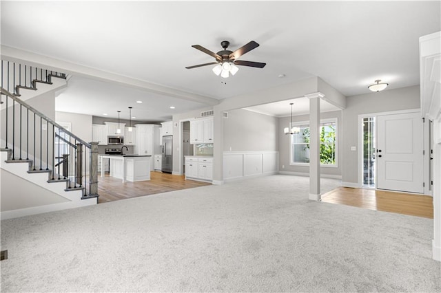 16779 S Durango St, Olathe, KS 66062 - unfurnished living room featuring light carpet, ceiling fan, stairs, a chandelier, and recessed lighting