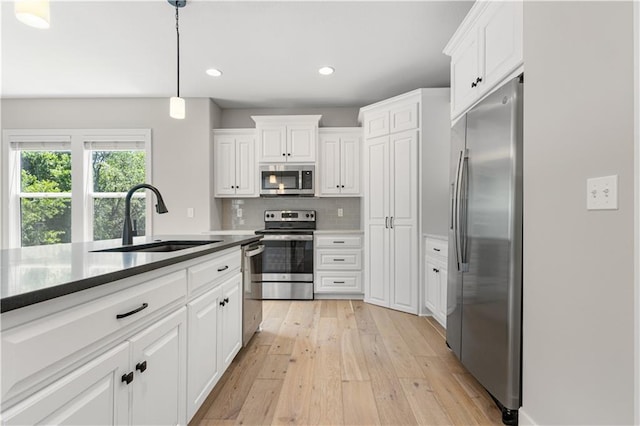 16779 S Durango St, Olathe, KS 66062 - kitchen featuring stainless steel appliances, light wood-style flooring, white cabinetry, recessed lighting, and hanging light fixtures