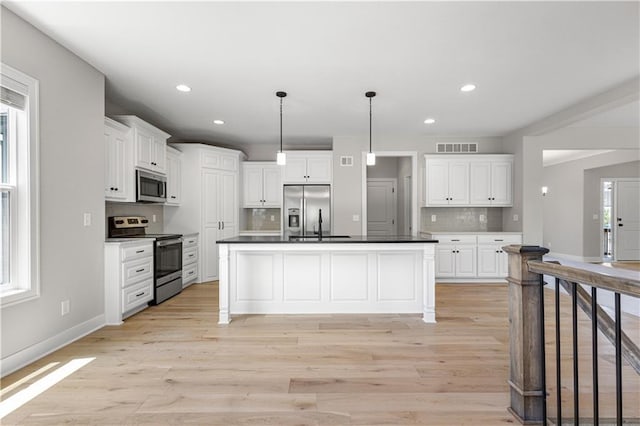 16779 S Durango St, Olathe, KS 66062 - kitchen with stainless steel appliances, light wood finished floors, tasteful backsplash, white cabinets, and recessed lighting