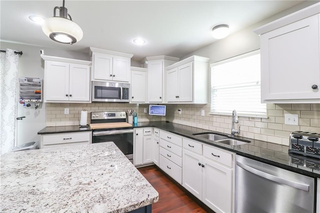 968 E Market St, Warrensburg, MO 64903 - kitchen with stainless steel appliances, white cabinetry, decorative backsplash, pendant lighting, and dark wood finished floors