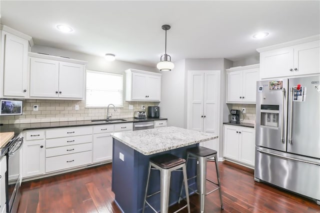 968 E Market St, Warrensburg, MO 64903 - kitchen featuring appliances with stainless steel finishes, decorative backsplash, dark wood finished floors, recessed lighting, and white cabinets