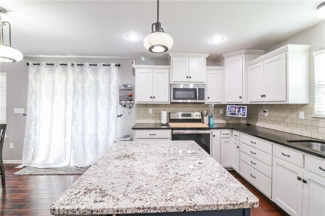 968 E Market St, Warrensburg, MO 64903 - kitchen with appliances with stainless steel finishes, white cabinets, tasteful backsplash, a kitchen island, and recessed lighting