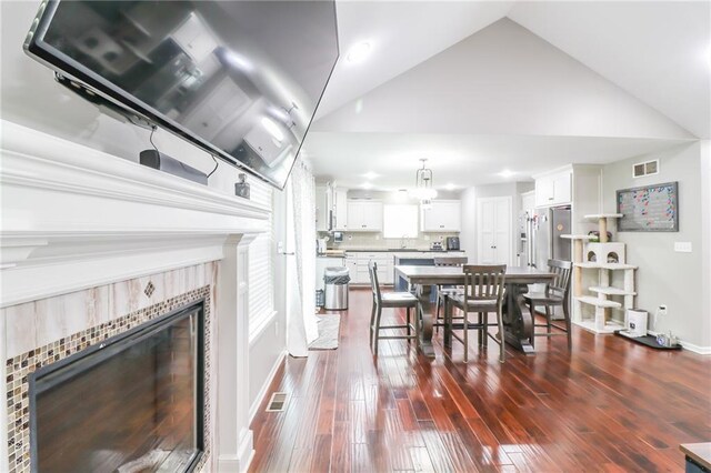 968 E Market St, Warrensburg, MO 64903 - dining space featuring a tile fireplace, high vaulted ceiling, and dark wood finished floors