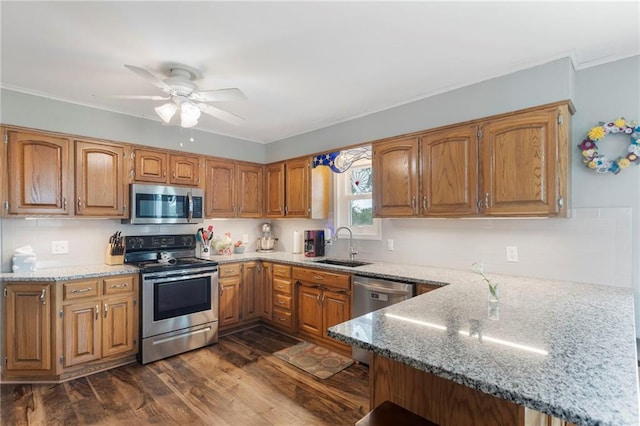 24245 K 68 Hwy, Paola, KS 66071 - kitchen with appliances with stainless steel finishes, dark wood-style flooring, light stone countertops, a peninsula, and brown cabinetry