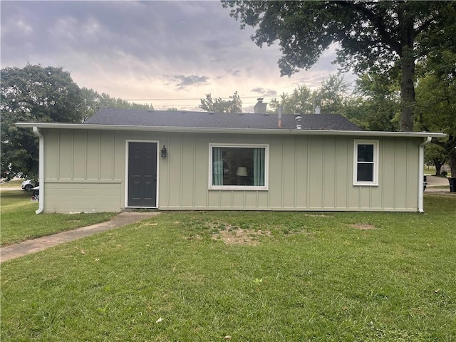 400 N Institute St, Richmond, MO 64085 - view of front facade with board and batten siding, a front yard, and a chimney