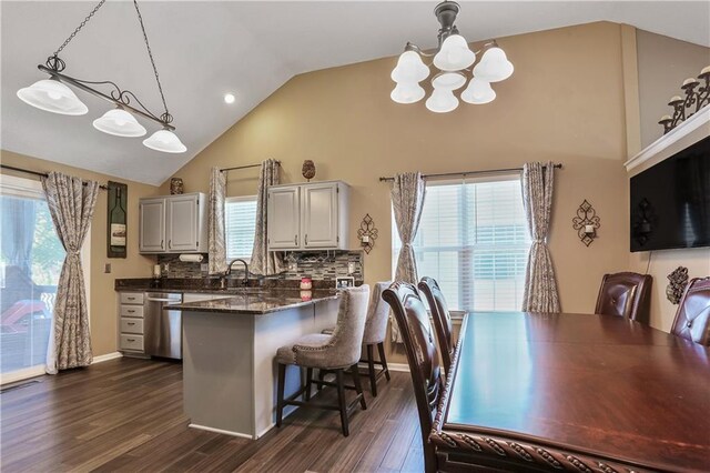 1641 N Hunter Dr, Olathe, KS 66061 - kitchen featuring a chandelier, dishwasher, dark wood finished floors, a kitchen bar, and high vaulted ceiling
