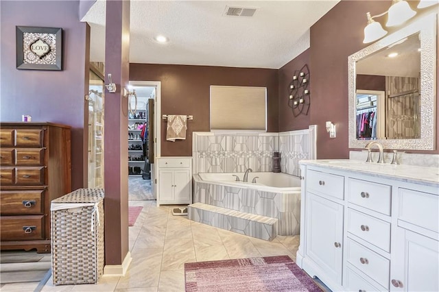 1641 N Hunter Dr, Olathe, KS 66061 - bathroom with vanity, a garden tub, a walk in closet, and a textured ceiling