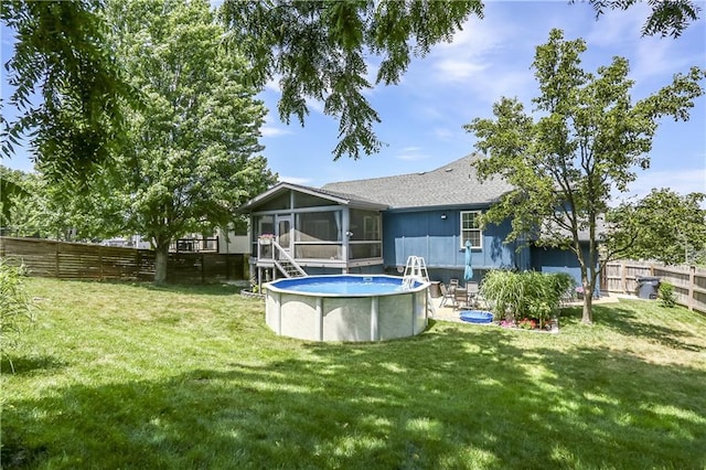 1641 N Hunter Dr, Olathe, KS 66061 - rear view of property featuring a sunroom, a fenced backyard, and a shingled roof